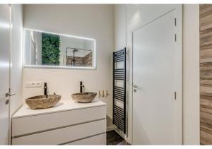 two sinks on a counter in a bathroom with a mirror at The Heart of Leuven in Leuven