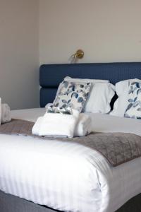 Una cama blanca con almohadas azules y blancas. en Redcliffe Hotel, en Paignton
