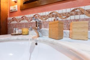ein Waschbecken mit einem Wasserhahn und Seifenspendern aus Holz in der Unterkunft Apartamentos Rurales San Feliz in Pola de Lena