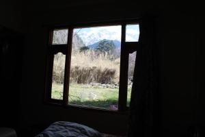 a window in a bedroom with a view of a mountain at K For Kasol in Kasol
