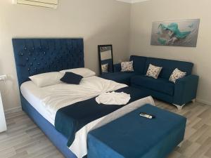 een slaapkamer met een bed en een blauwe bank bij The Temple Butik Otel in Kuşadası