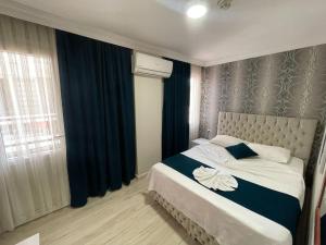 een slaapkamer met een groot bed met blauwe gordijnen en een raam bij The Temple Butik Otel in Kuşadası