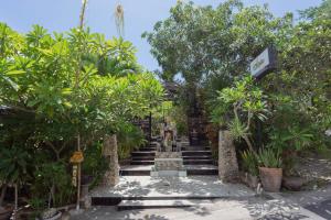 a set of stairs in a garden with trees at Ratu Cottage by OurStory Travels in Nusa Penida