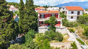 a house on a hill with trees and houses at Apartman Damir in Sumartin