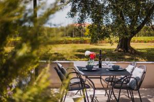 een zwarte tafel met stoelen en een vaas met bloemen bij Apartments Olea in Novigrad Istria