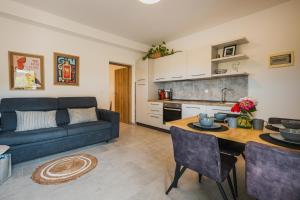 a living room with a blue couch and a table at Apartments Olea in Novigrad Istria
