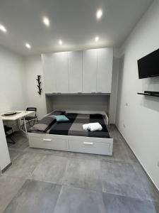 a bedroom with a bed with white cabinets and a desk at Sermoneta10 in Naples
