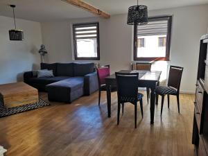 a living room with a couch and a table and chairs at Au 19 de Lina in Hoerdt
