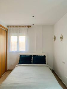 ein Schlafzimmer mit einem großen Bett mit blauen Kissen in der Unterkunft ESPAGNE, MANILVA, ANDALOUSIE , PENTHOUSE VUE MER 7 PERSONNES in Manilva