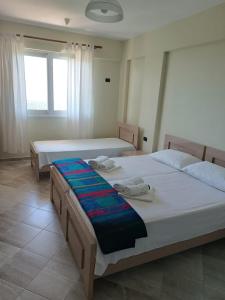 2 łóżka w pokoju hotelowym z ręcznikami w obiekcie Vila Aleks w mieście Vuno