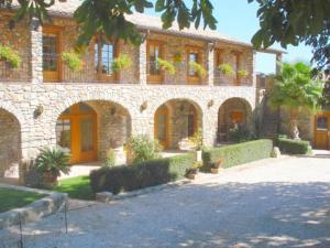 a large brick building with doors and a courtyard at Le Clos des Arts in Les Mages
