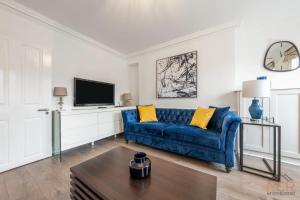 salon z niebieską kanapą i telewizorem w obiekcie Mayfair Residences w Londynie