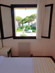 a bedroom with a bed and a window at Tamerici in Cavallino-Treporti