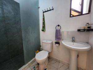 e bagno con servizi igienici, lavandino e doccia. di Jamiitown Homes a Kilifi