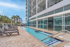 a swimming pool in front of a building at Beachfront Condo with Stunning View Multiple Pools on BV 7th Floor in Myrtle Beach