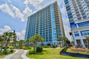 a tall building with palm trees in a park at Beachfront Condo with Stunning View Multiple Pools on BV 7th Floor in Myrtle Beach