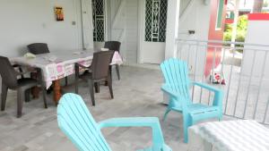 comedor con sillas azules y mesa en Maison de 3 chambres avec piscine partagee jardin clos et wifi a Sainte Anne a 3 km de la plage, en Sainte-Anne