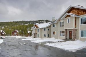 a row of houses in a parking lot with snow at Condo in Cedar Creek with Shuttle to Big Sky Resort! in Gallatin Gateway