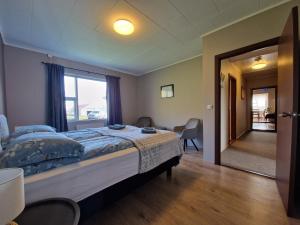 a bedroom with a large bed and a window at Helgafell Guesthouse in Stykkishólmur