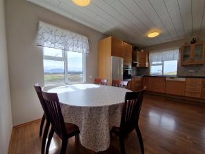 a kitchen with a table and chairs and a large window at Helgafell Guesthouse in Stykkishólmur