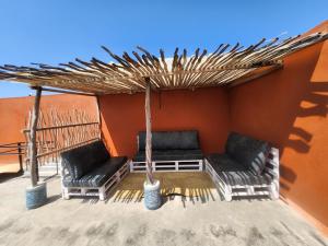 2 sillas y una sombrilla en el patio en Jamiitown Homes en Kilifi