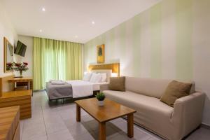 a living room with a couch and a bed at Agrilia Hotel Adults Only in Laganas