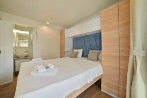 a bedroom with a large white bed with towels on it at Kamp Rožac in Trogir