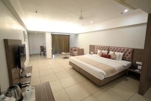 a hotel room with a bed and a television at Hotel Dwarkamai, A Pure Vegetarian Hotel in Nagpur