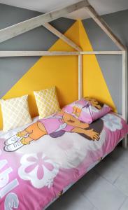 a childs bed with a yellow and pink canopy at Maison de 3 chambres avec jardin clos et wifi a Gefosse Fontenay a 1 km de la plage in Géfosse-Fontenay