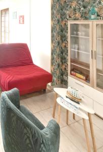 a living room with a bed and a chair and a table at Maison de 3 chambres avec jardin clos et wifi a Gefosse Fontenay a 1 km de la plage in Géfosse-Fontenay