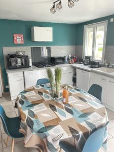 a kitchen with a table and some chairs and a table at Maison de 3 chambres avec jardin clos et wifi a Gefosse Fontenay a 1 km de la plage in Géfosse-Fontenay
