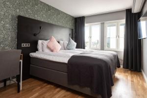 1 dormitorio con 1 cama grande con almohadas rosas en Clarion Collection Hotel Plaza en Karlstad
