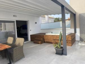 un patio con bañera, mesa y sillas en Iceberg Suite with Jacuzzi, en Kalamaki