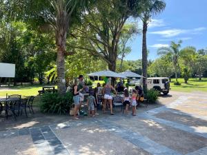 een groep mensen die rond een tafel in een park staan bij Areena Riverside Resort in Kwelera