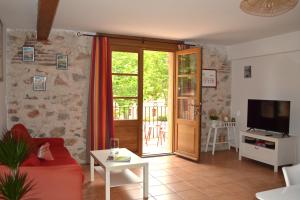 een woonkamer met een rode bank en een glazen schuifdeur bij Mas Sant Jordi in Alénya