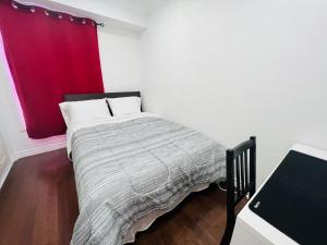 una camera con letto con tenda rossa di ComfyRoom a Toronto