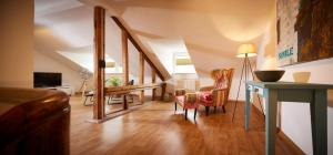 a living room with a staircase with a table and chairs at Mosel-Loft in Bernkastel-Kues