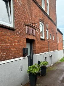 un edificio in mattoni con pentole di piante di fronte di Borgo Antico Hotel a Fehmarn