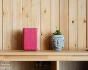 een roze boek en een vaas op een plank bij Alma house - Grey in Alma-Ata