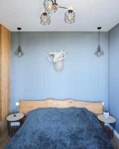 een blauwe slaapkamer met een houten bed en 2 tafels bij Alma house - Grey in Alma-Ata