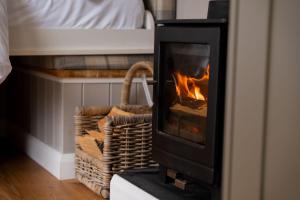 Una chimenea en una habitación con una cama al fondo. en Driftwood & Hot Tub, en Fort William