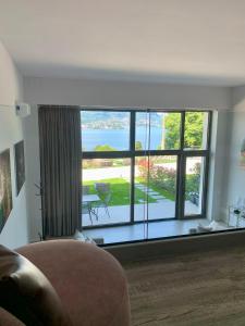 a living room with a large window with a view at Panorama Loft Apartments in Stresa