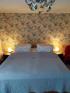 1 dormitorio con cama azul y papel pintado con motivos florales en Einliegerwohnung in Gissigheim en Königheim