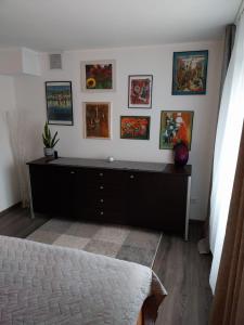 a bedroom with a dresser with paintings on the wall at Einliegerwohnung in Gissigheim in Königheim