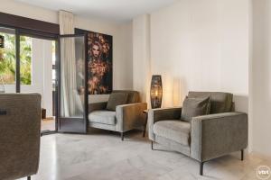 a living room with two chairs and a painting on the wall at ViVi Homes - El Sembrador Pool, Terrace & Golf in La Cala de Mijas
