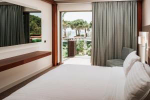 (Ortunc Hotel - Cunda Island (Adult Only في أيفاليك: غرفه فندقيه بسرير ونافذه