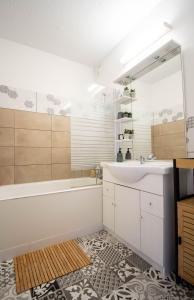 a bathroom with a sink and a tub and a mirror at Cocooning in Mont-de-Marsan