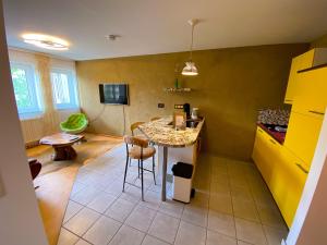 a kitchen with a table and a yellow wall at City Apartment Markdorf in Markdorf