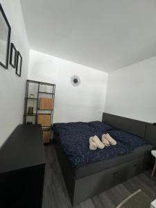 a bedroom with a bed with two shoes on it at Hobití apartmán - Sam in Radslav