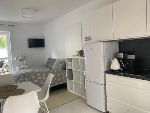 ポビエロボにあるVIlla Mare Apartamentyの小さなキッチン(ベッド1台、白い冷蔵庫付)